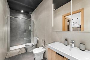 een badkamer met een wastafel, een toilet en een douche bij El Coloso Loft 1 in Benalmádena