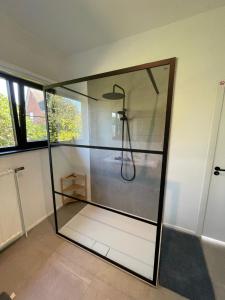 La salle de bains est pourvue d'une douche et d'une paroi en verre. dans l'établissement BierBee, à Bierbeek