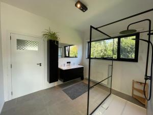 een badkamer met een glazen douche en een wastafel bij BierBee in Bierbeek