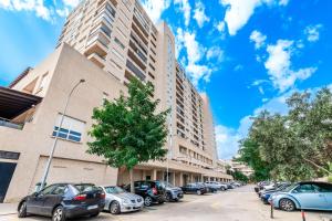 een rij auto's geparkeerd voor een gebouw bij El Coloso Loft 1 in Benalmádena