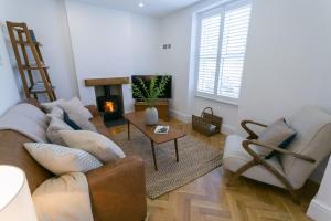 a living room with a couch and chairs and a fireplace at Shell Cottage in Menai Bridge
