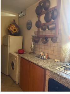 uma cozinha com um frigorífico e um balcão com uma máquina de lavar roupa em Mamma Rosaria em Pompeia