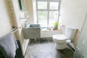 a bathroom with a toilet and a sink and a window at The Moorings in Menai Bridge +75 photos
