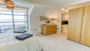 a bedroom with a bed and a large window at The Quay in Benllech