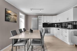 a kitchen and dining room with a table and chairs at The Urban Cityscape in Tromsø