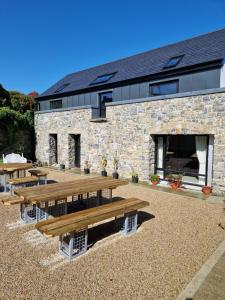 una fila de bancos de madera frente a un edificio en The Forum-Mountmellick - Coachhouse, en Mountmellick