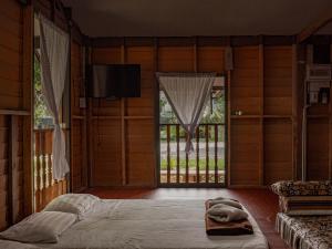 ein Schlafzimmer mit einem großen Bett und einem großen Fenster in der Unterkunft Bakkahland Farm and Resort in Pattani