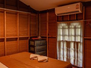 a room with a bed and a heater and a window at Bakkahland Farm and Resort in Pattani