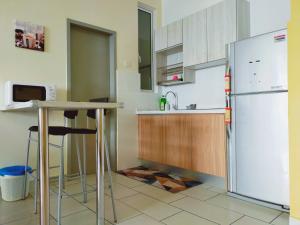 uma cozinha com um frigorífico branco e uma mesa em Palmyra Residence em Kajang