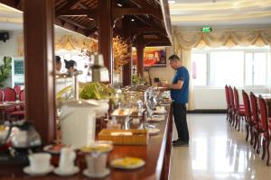 a man standing at a bar in a restaurant at Pleiku & Em Hotel by Gia Lai Tourist in Pleiku