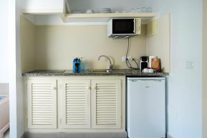 a small kitchen with a sink and a refrigerator at Apartamentos Es Caló in Es Calo