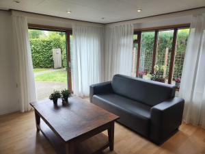 een woonkamer met een bank en een salontafel bij Modern Chalet in Garderen with Private Garden in Garderen