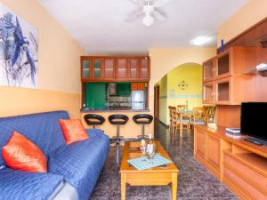 a living room with a blue couch and a kitchen at Live Icod Buen Paso in Icod de los Vinos