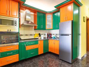 a kitchen with green and orange cabinets and a refrigerator at Live Icod Buen Paso in Icod de los Vinos
