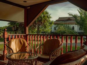2 sillas y una mesa en el balcón en Bakkahland Farm and Resort, en Pattani