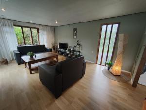 een woonkamer met een bank en een tafel bij Modern Chalet in Garderen with Private Garden in Garderen
