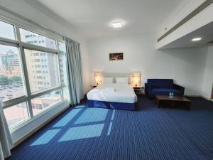 a hotel room with a bed and a blue chair at Havana Holiday Homes Oud Metha in Dubai