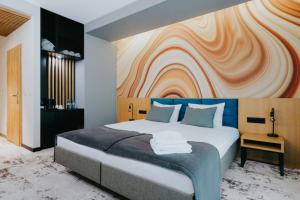 1 dormitorio con 1 cama grande y pared colorida en Aspen Prime Ski & Bike Resort - basen, sauna, jacuzzi, siłownia w cenie pobytu en Głuchołazy