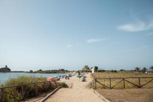 un groupe de personnes sur une plage près de l'eau dans l'établissement Rooms Via XX Settembre, à Capoterra