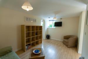 een woonkamer met een bank en een tafel bij Five Cottages in AONB and a Hobbit House! in Canterbury