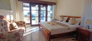 a bedroom with a bed and a couch and a window at Villa Lilly Sea View Pool Villa in Umeanyar