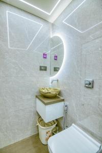a bathroom with a sink and a toilet and a mirror at La Hotel Metro near BKC in Mumbai