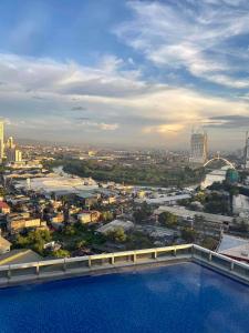 Classy 2BR Suite at Eastwood City with Pool and City Skyline View في مانيلا: اطلالة على مدينة من اعلى المبنى