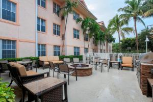 a patio with chairs and tables in front of a building at Residence Inn West Palm Beach in West Palm Beach