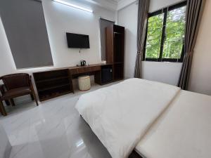 Schlafzimmer mit einem Bett und einem Flachbild-TV in der Unterkunft KL Retreat Hotel in Thanh Hóa
