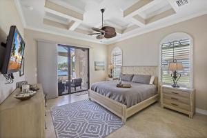 une chambre avec un lit et une télévision à écran plat dans l'établissement Opulent waterfront home with pool, spa, dock and deck, à Marco Island