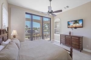 une chambre avec un lit et un ventilateur de plafond dans l'établissement Opulent waterfront home with pool, spa, dock and deck, à Marco Island 50 autres photos