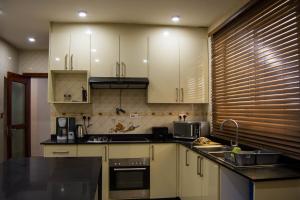 a kitchen with white cabinets and a black counter top at Ista Villa in Lusaka