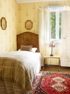 a bedroom with a bed and a window and a rug at Visnes Hotel Stryn in Stryn