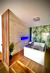 a large bath tub in a room with a plant at Jacuzzi Apartment in Baia Mare
