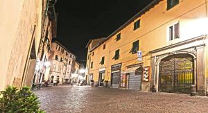 una strada cittadina vuota di notte con edifici di B&B Antico Cancello a Lucca