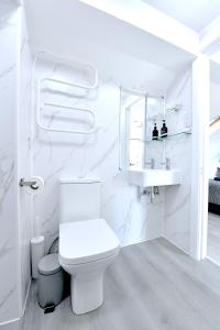 a white bathroom with a toilet and a sink at Stylish Studios by Luxestays Fulham in London +178 photos