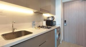 a small kitchen with a sink and a stove at Modern Furnished Studio Farhad Azizi Residence Al Jaddaf in Dubai