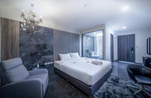Sibtis Hotel في لامبانغ: غرفة نوم بسرير واريكة وكرسي