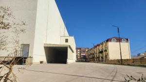 a large white building with a large garage at 15минут до центра Баку in Xirdalan +2 photos
