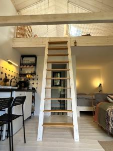 a loft bed with a ladder in a room at Chata Lila Bee in Hodruša
