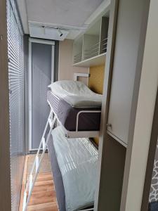 ein kleines Zimmer mit 2 Etagenbetten und einem Fenster in der Unterkunft AquaHome - Woudrichem - Bijzonder overnachten op een houseboat aan de Afgedamde Maas in Woudrichem