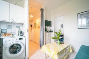 una cocina con lavadora y mesa en L'Évasion Aulnaysienne - Appt pour 4, en Aulnay-sous-Bois