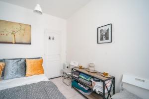 Un pequeño dormitorio con una cama y una mesa. en L'Évasion Aulnaysienne - Appt pour 4, en Aulnay-sous-Bois