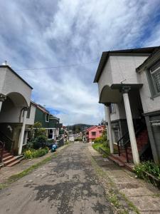 una calle vacía en una pequeña ciudad con casas en Sumana Stays en Ooty