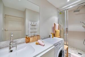 a bathroom with a washing machine and a sink at Bord de Mer - Charmant studio vue mer in Trouville-sur-Mer