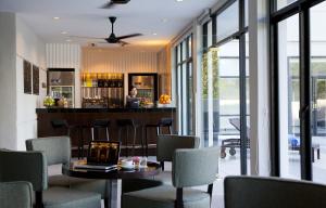 AC Hotel by Marriott Kuantan في كُوانتان: مطعم يحتوي على بار مع جهاز كمبيوتر محمول على طاولة