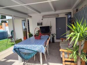 a table and chairs on a patio with a table and a television at Apartamento situado a 3minutos del PTA campanillas in Málaga