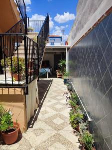 Apartamento situado a 3minutos del PTA campanillas في مالقة: فناء به سلالم ونباتات على مبنى