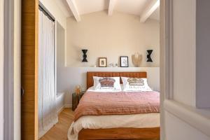 - une chambre avec un lit aux murs blancs et du parquet dans l'établissement La plage et les commerces à pieds !, à Saint-Cyr-sur-Mer