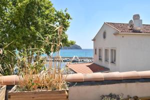 d'un balcon offrant une vue sur une maison et l'océan. dans l'établissement La plage et les commerces à pieds !, à Saint-Cyr-sur-Mer